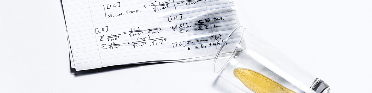 Photo of a paper with math problems and an almost empty glass with a small amount of liquid inside.